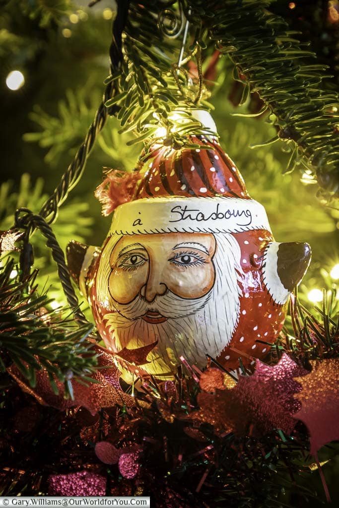 A round painted Santa christmas decoration from strasbourg hanging in our christmas tree