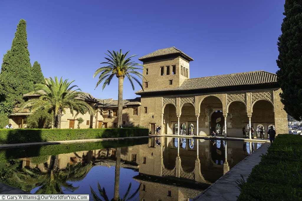 The el partal refelected in the pond in front of it in the alhambra palace in granada, spain