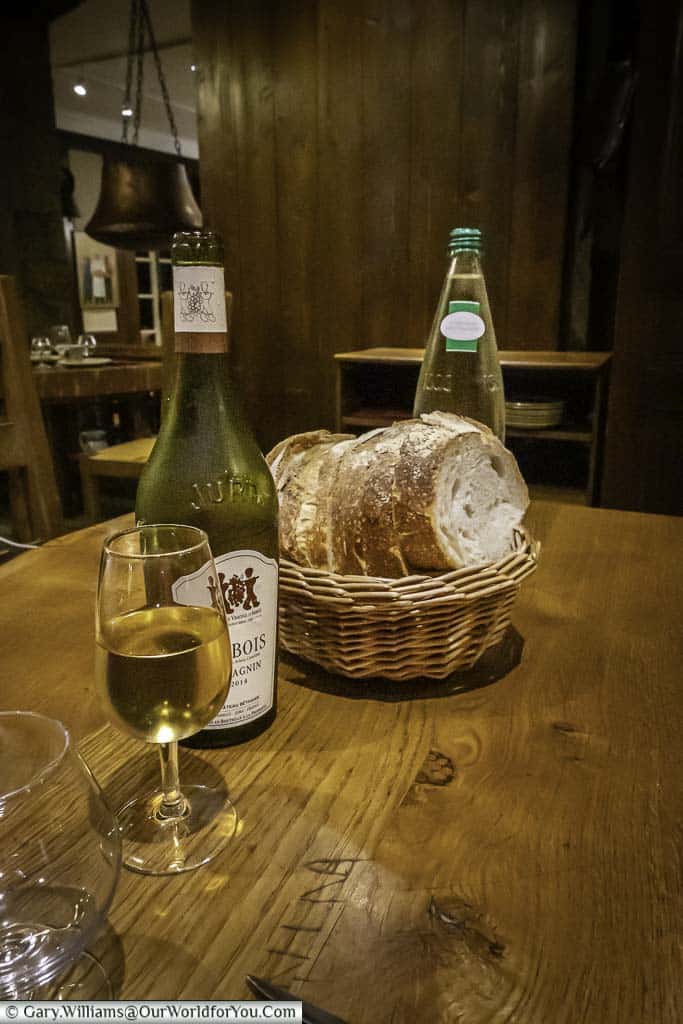 A glass of the vin jaune next to a basket of bread in Arbois, France