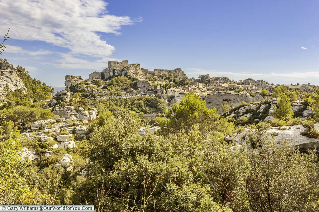 A view in the distance of the hillside town of Les Baux-de-Provence with the remains of its historic ruins atop the craggy rockfac