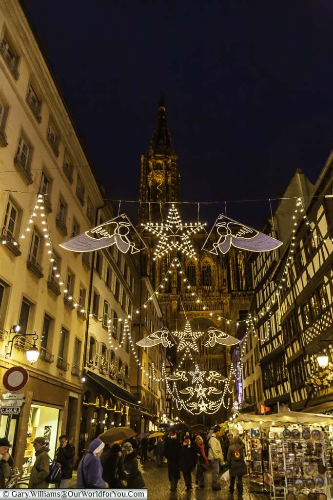 Looking down Rue Mercière with its hanging christmas lights against the backdrop of the illuminated gothic cathedral.