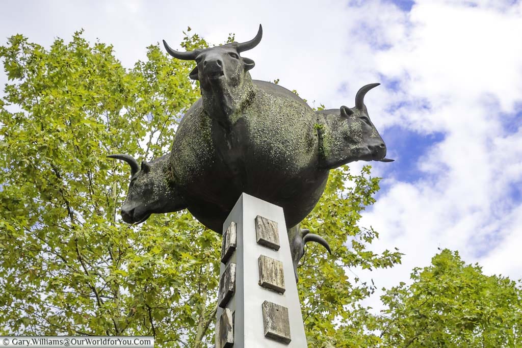 The El Mundo de Toros monument with four bull heads mounted on a sphere atop a column reflects pamplona's association with bull fighting