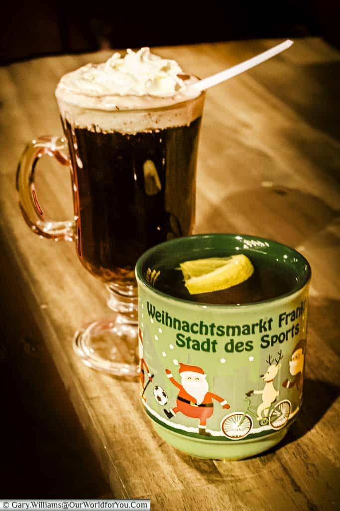 Two drinks from the Frankfurt's Christmas markets. The first is a mug of Frankfurt's speciality apple gluhwein; the other is a glass Irish-Coffee style glass with a cherry gluhwein, topped with cream.