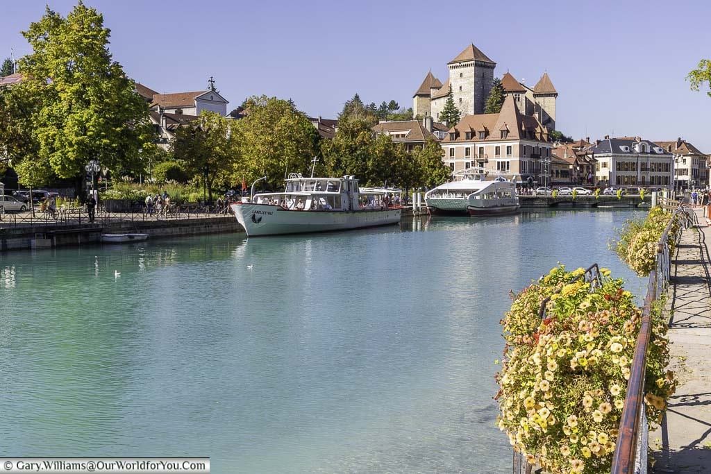 Looking back on the Chateaux d'Annecy from the opal-coloured waters of Quai Napoleon III in annecy in the haute-savoie region of france.