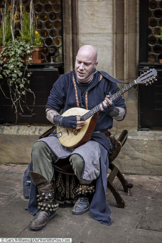 The muscian, luc arbogast, playing a traditional Irish bouzouki seated close to strasbourg's christmas markets