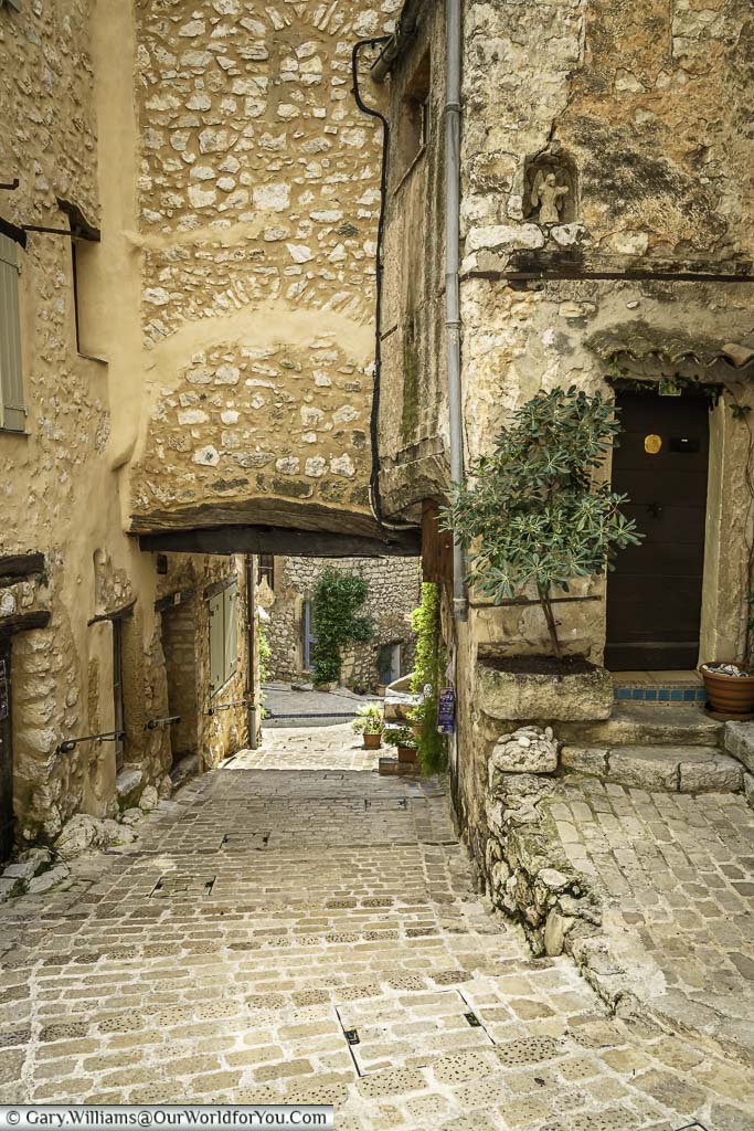 A small cobbled lane heading under an archway in a house in the provencal village of Tourrettes-sur-Loup