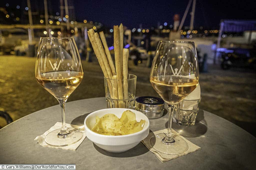 Two glasses of rosé wine in front of the harbour of Villefranche-sur-Mer at night.