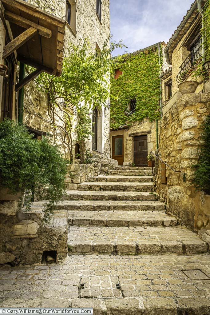 Sandy coloured stone steps leading up between stone houses in tourrettes-sur-loup in the provence region of france