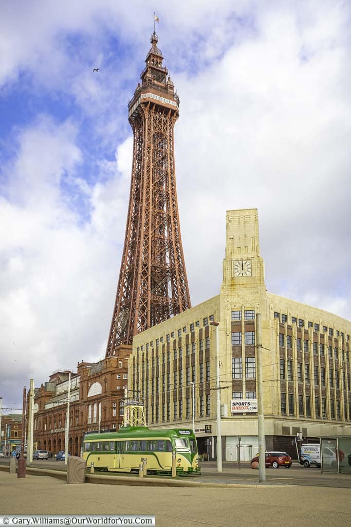 The Blackpool tower with a historic tram at its base.