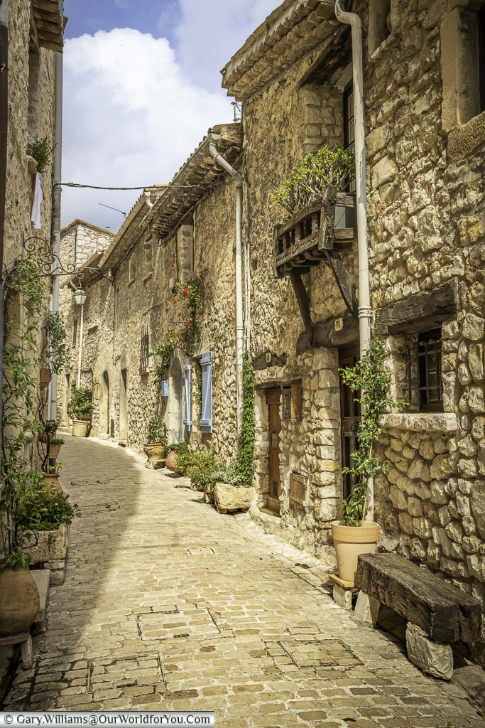 A small cobbled lane lined with stone houses in the village of tourrettes sur loup in provence, france