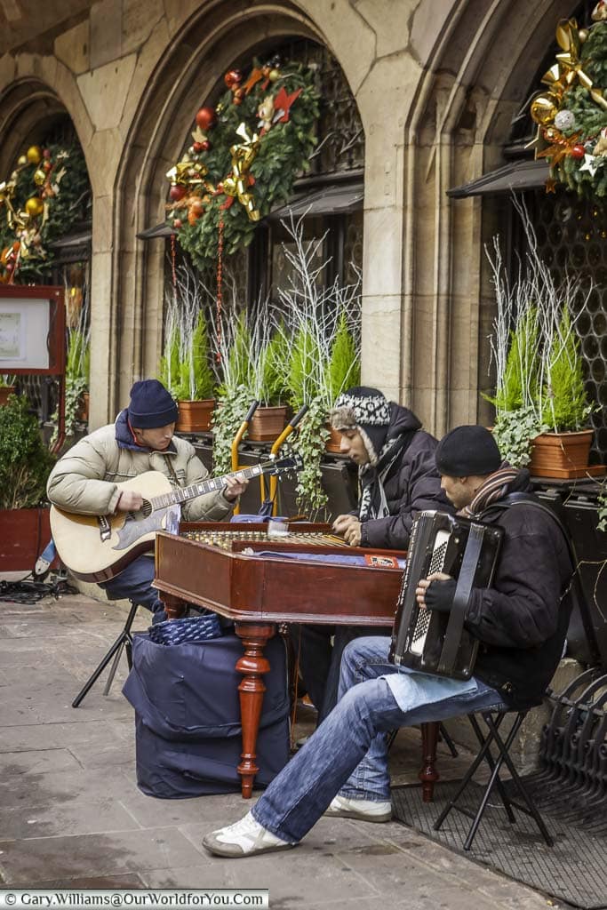 A group of street musicians with their instraments at the edge of strasbourg's christmas market in place de la cathédrale.