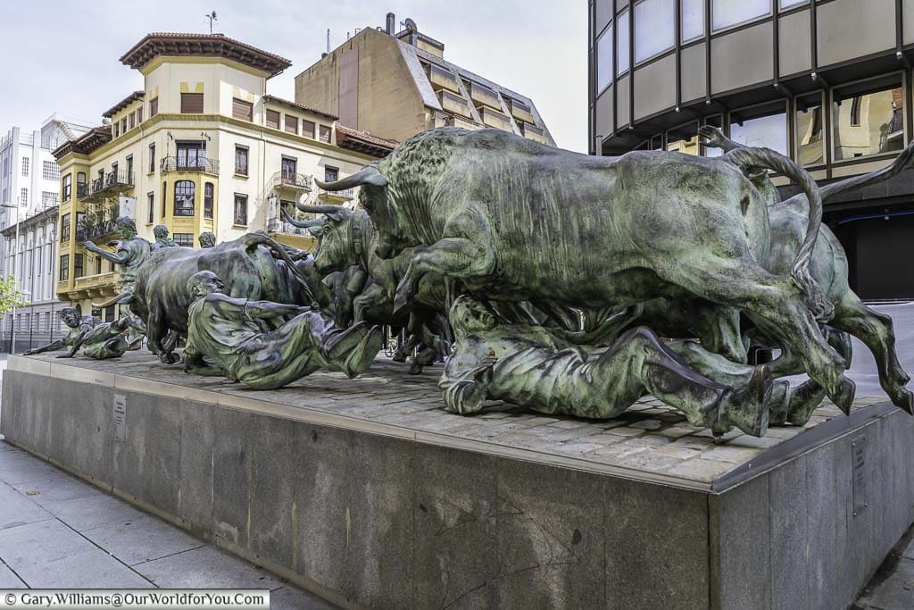 The encierro monument, a bronze statue depicted a mixed group of men and bulls as they charge through the streets of pamplona in spain