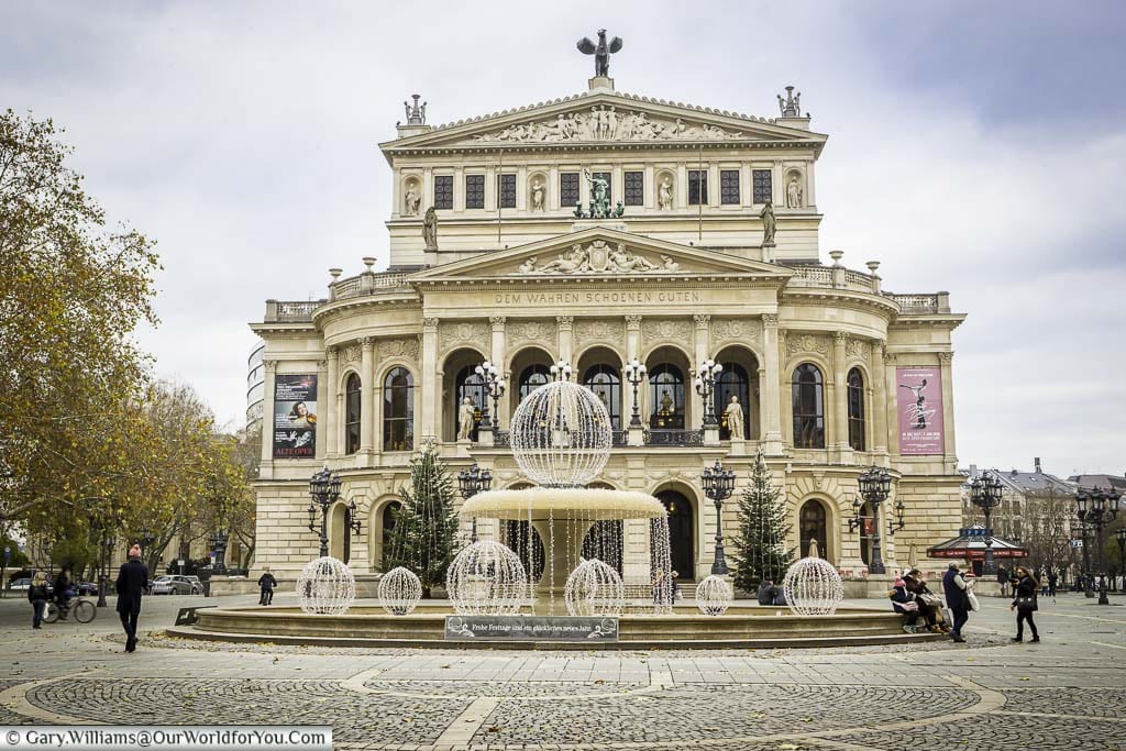 Frankfurt's old opera house from behind the Lucae-Brunnen fountain in Opernplatz. The sandstone coloured neoclassical styled building was destroyed during the Second World War and completely rebuilt, reopening in 1981.