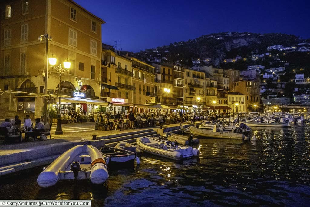 The bustling quayside of Villefranche-sur-Mer in the evening full of motor launched docked in the bay next to the restaurants