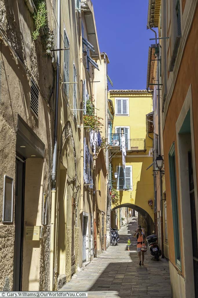 A narrow lane between bright coloured tall buildings in Villefranche-sur-Mer.