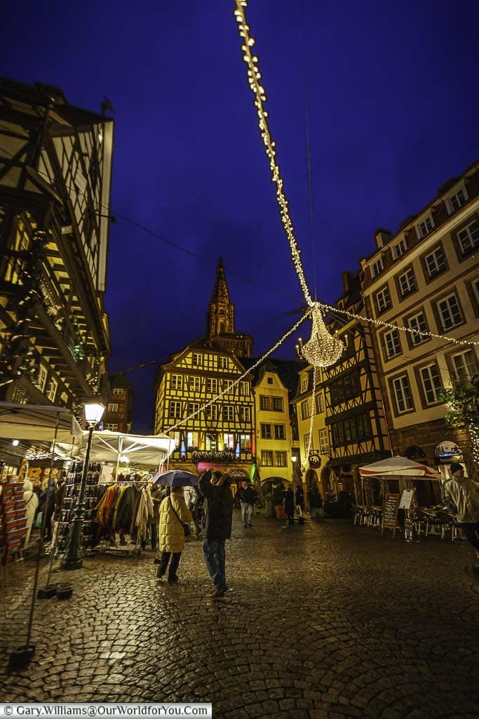 A square in strasbourg lined with medieval half-timbered buildings decorated for christmas