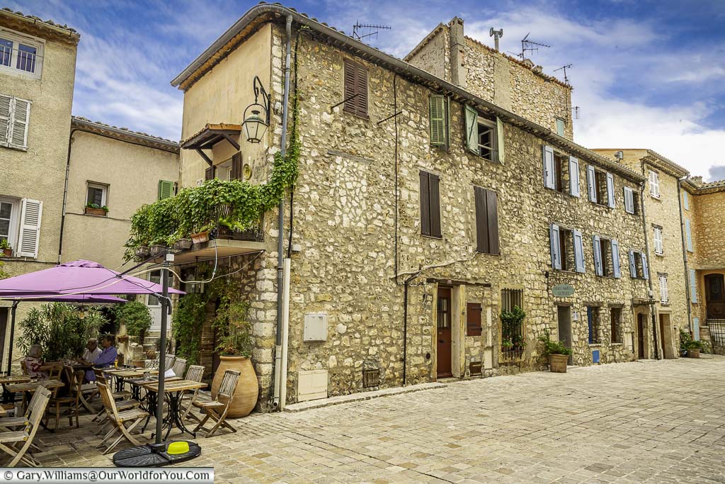 Shuttered stone buildings in a square in the heart of the village of tourrettes sur loup in provence, france