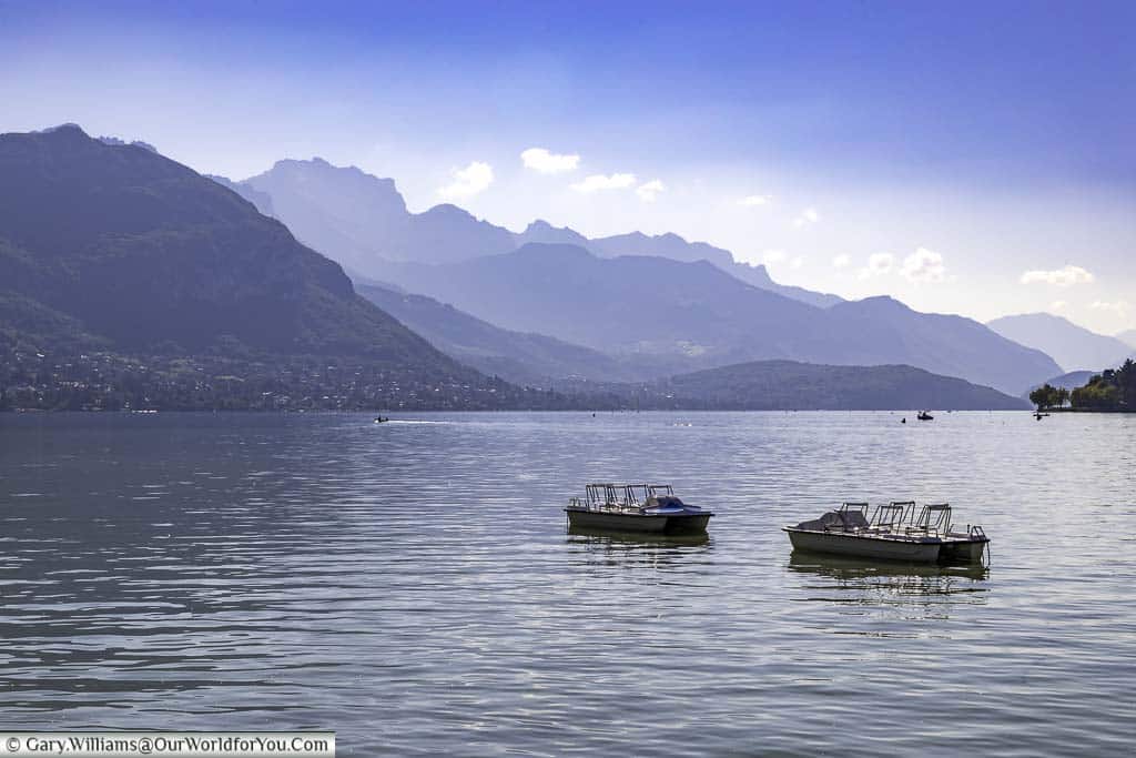 Two boats on a hazy Lake Annecy.