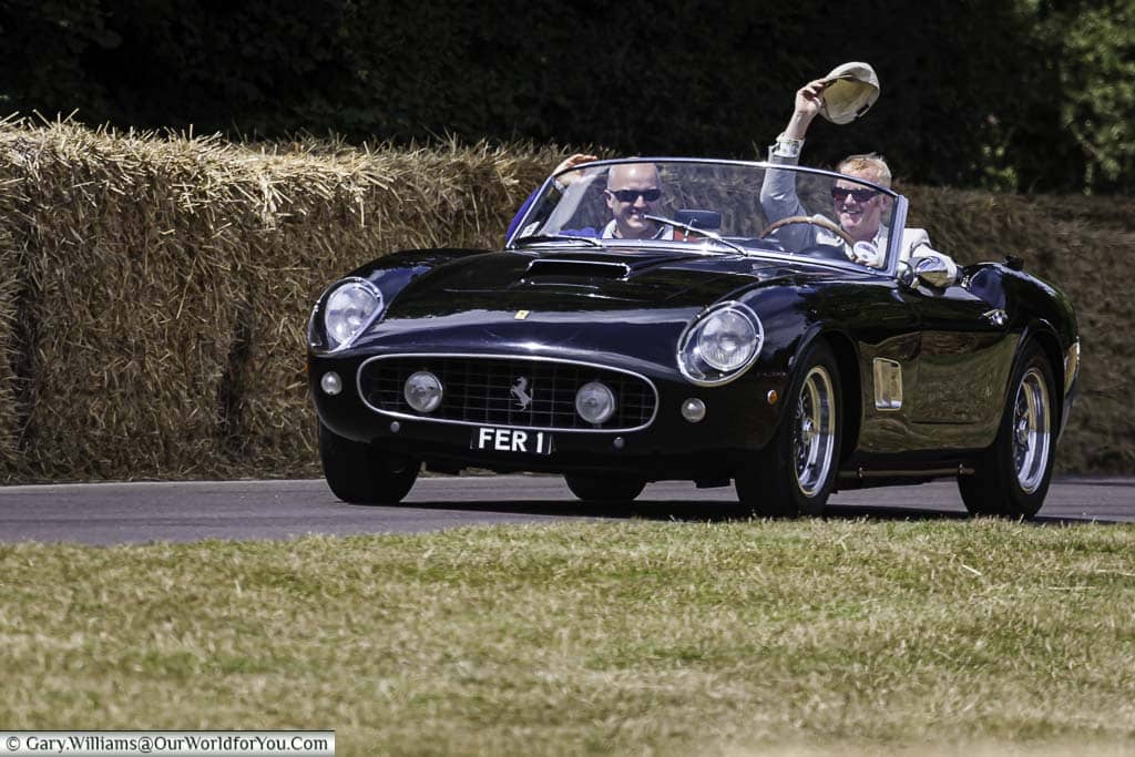 chris evans driving his black ferrari 250 gt spyder down the hill at the goodwood festival of speed