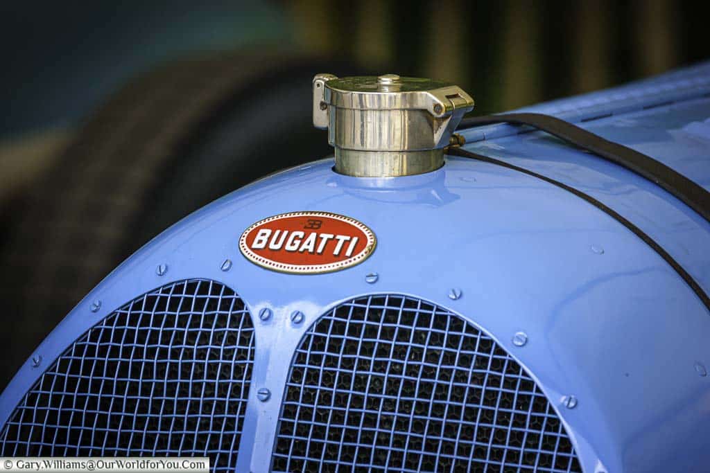 a close-up of the nose of a 1930's bugatti painted in french blue in the paddock at the goodwood festival of speed
