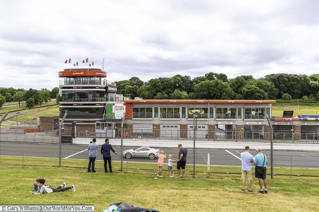 Family groups on the grass banks overlooking the circuit, race control and the pits of brands hatch motor racing circuit in kent, england
