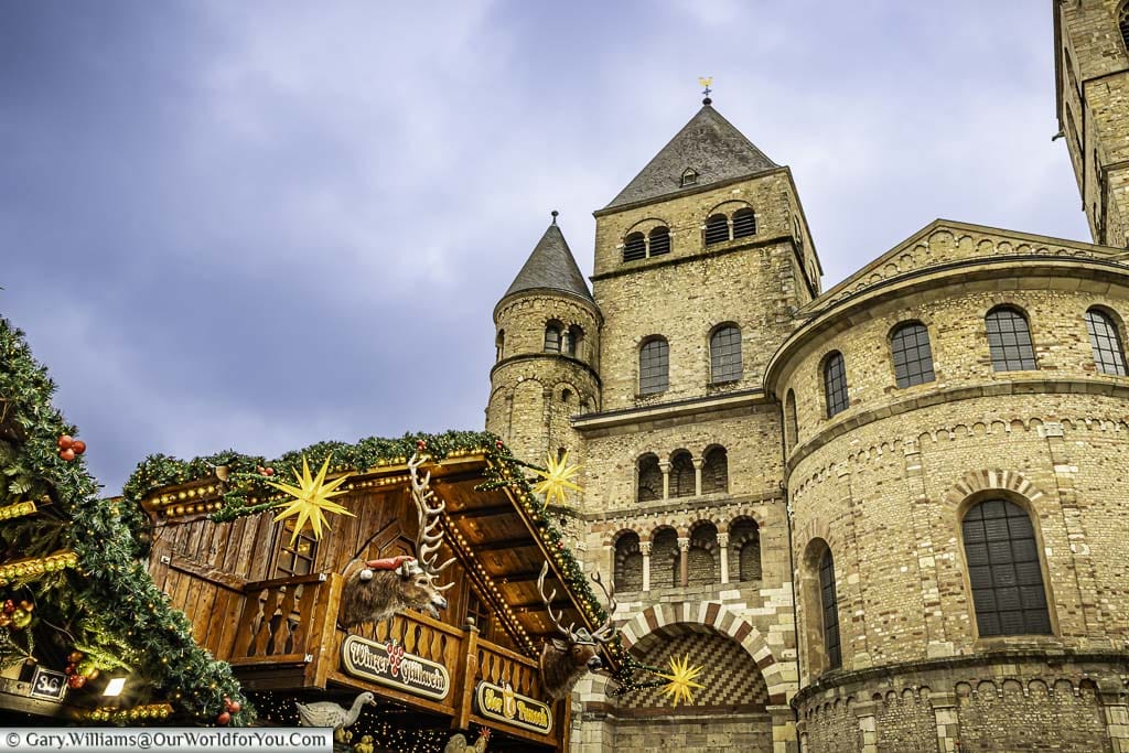 The ornately decorated drinks cabin in trier’s cathedral square christmas market with the historic Trier Dom in the background