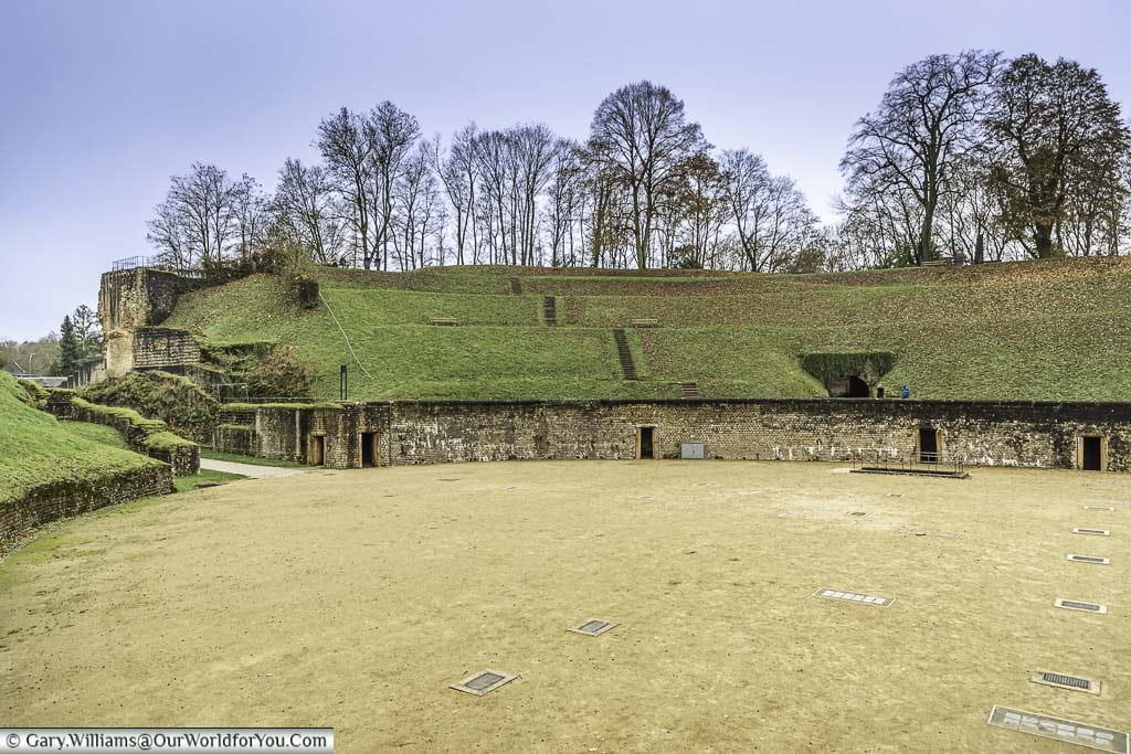 The entrance and sandy arena of the roman amphitheatre in trier in germany, as seen from the first tier of the now grassy stands