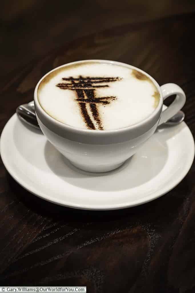 A cup of cappuccino stencilled with Franco’s 'F' logo at Franco’s Café in St James's, London