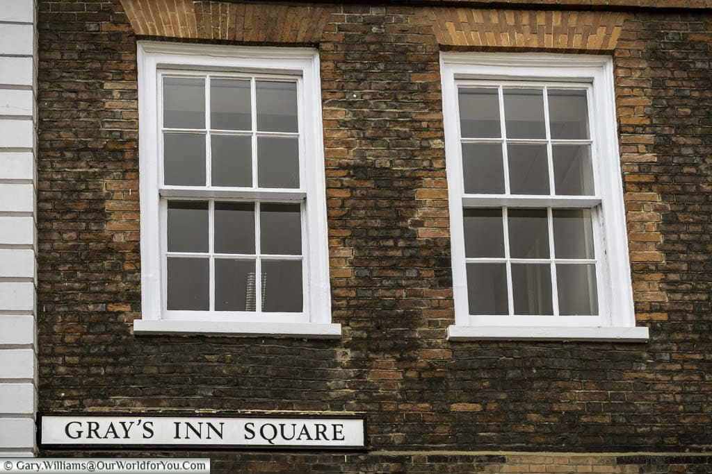 two white sash windows in a brick building in the corner of gray's inn square in the inns of court district of london