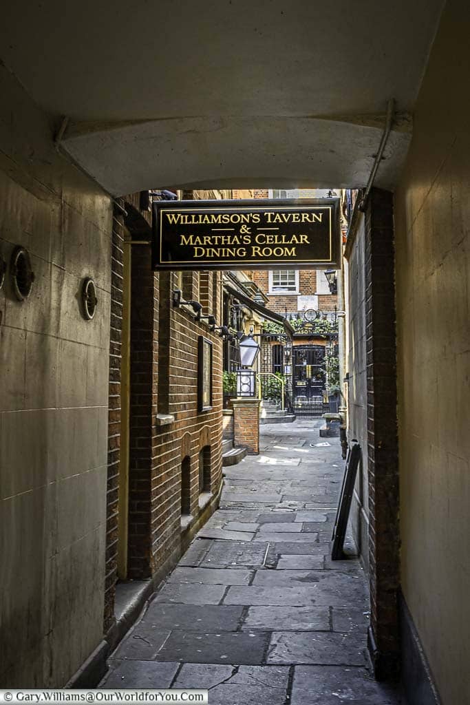 A narrow cobbled passageway in the city of london leading to williamson's tavern