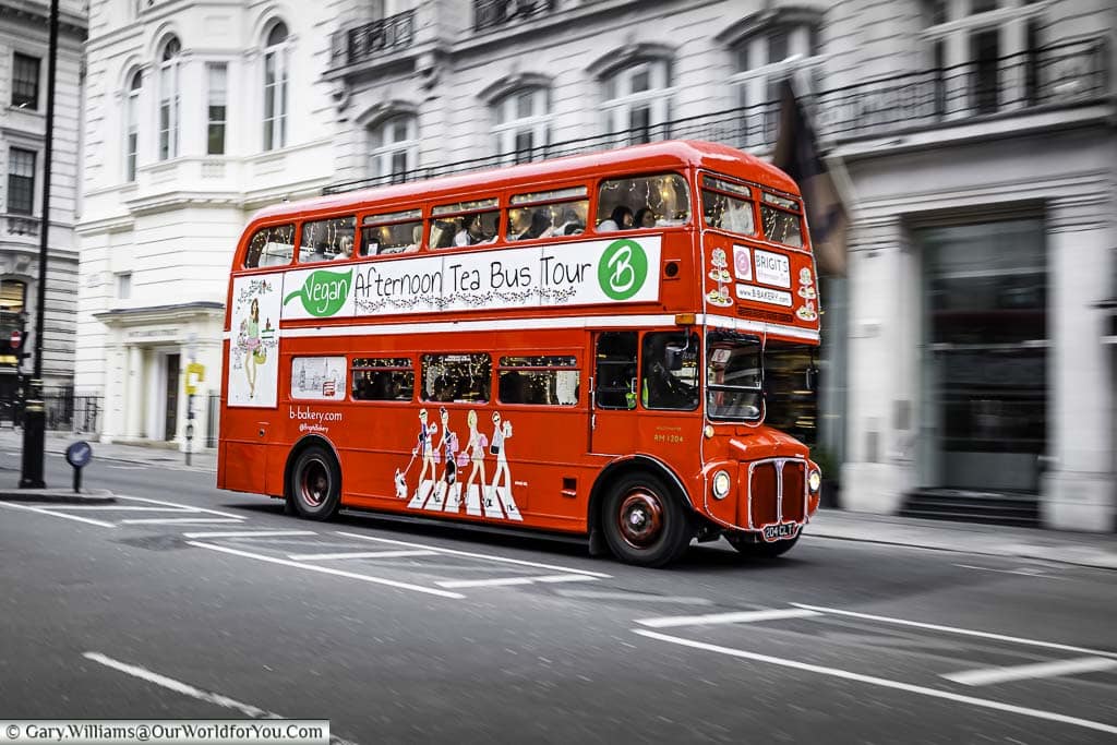 A traditional Routemaster London Red bus on and afternoon tea bus tour heading through the streets of St James' in London