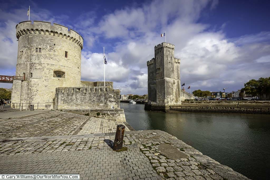 Medieval stone towers guarding the entrance to la rochelle harbour