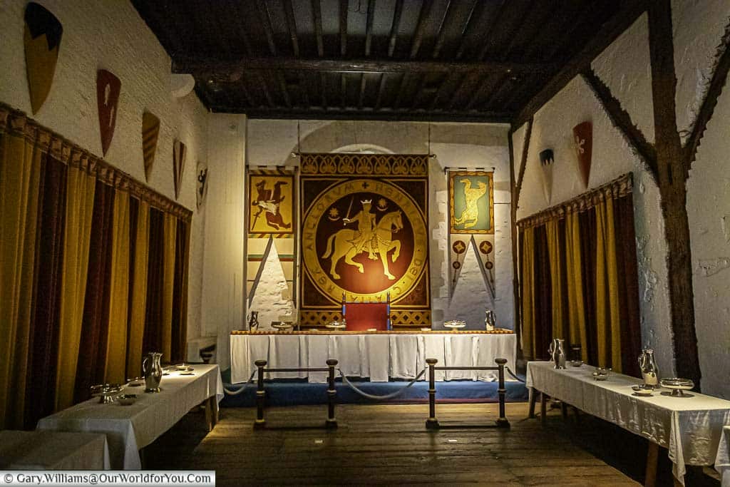 The dining area inside Dover Castle with drapes on the wall. The room very much has a medieval feel to it.
