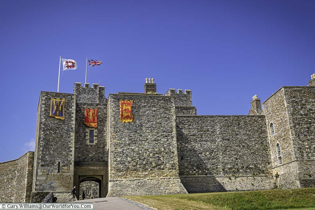 Dover Castle's outer walls draped with the standards of Henry II, and flying the flags of English Heritage & the Union Flag.
