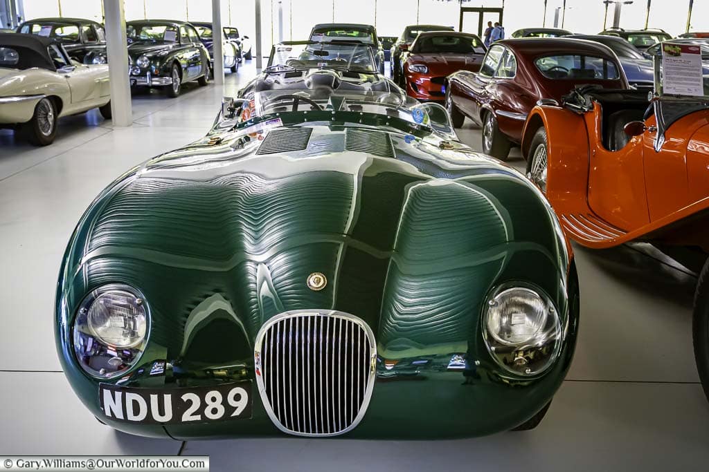 The frontal view of a 1953 Jaguar C-Type Le Mans car in a British Racing Green colour within the Jaguar Heritage collection at the British Motor Museum