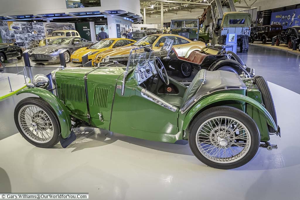 A side view of a green MG J type convertible sports car from the 1930s
