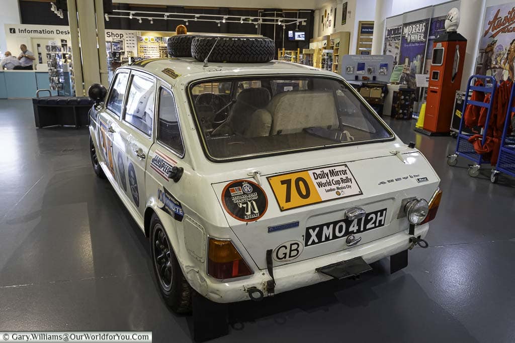 A rear view of a White 1971 Austin Max prepared for the Daily Mirror World Cup Rally in front of the information desk of the British Motor Museum