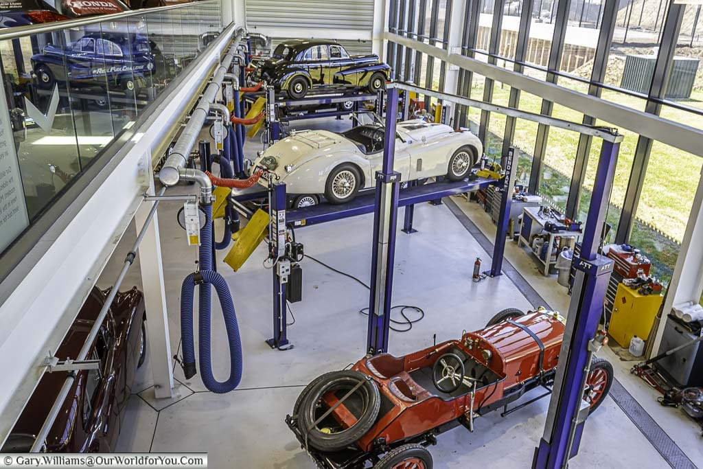 Looking down from the first floor to the Restoration Workshop of the Collections Centre in a separate building from the main museum. Here Three cars from different periods are being restored to their former glory.