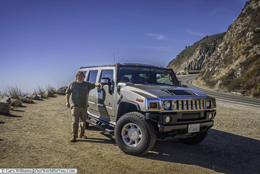 Gary standing next to our rental hummer h2 in a bronze colour next to pacific highway one in california