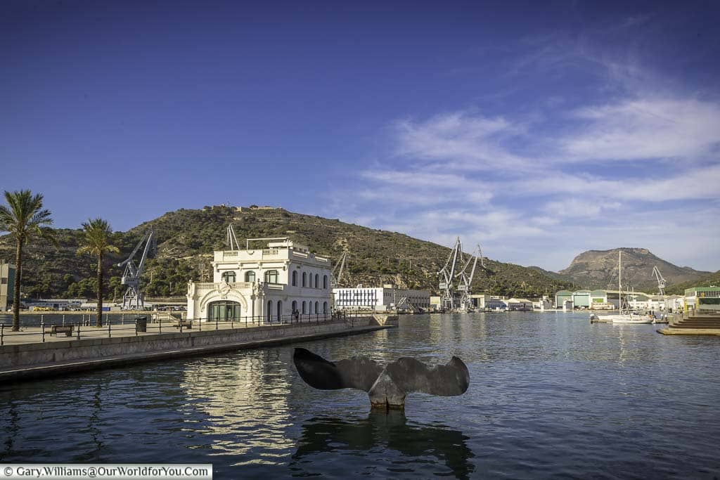 The whale tail installation in the water next to the old harbourmaster's building on the edge of Cartagena Harbour in historic Murcia in southern Spain
